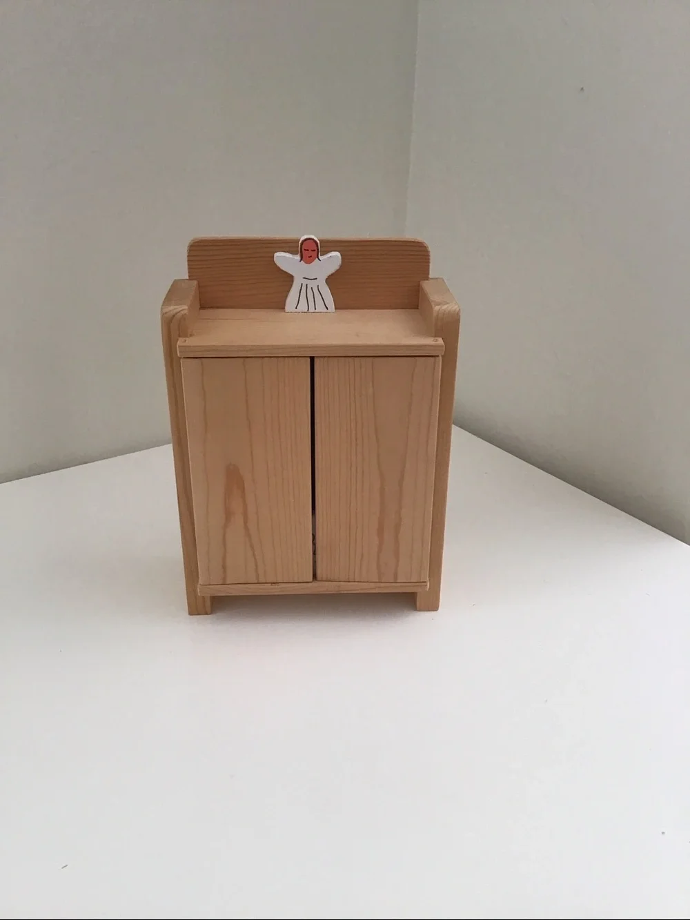 Handmade wooden cabinet holding a small wooden Nativity set
